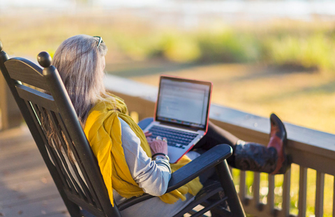 Woman on patio using laptop